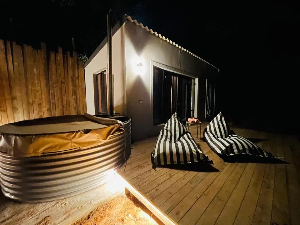 Wooden deck at night with hot tub and striped bean bags