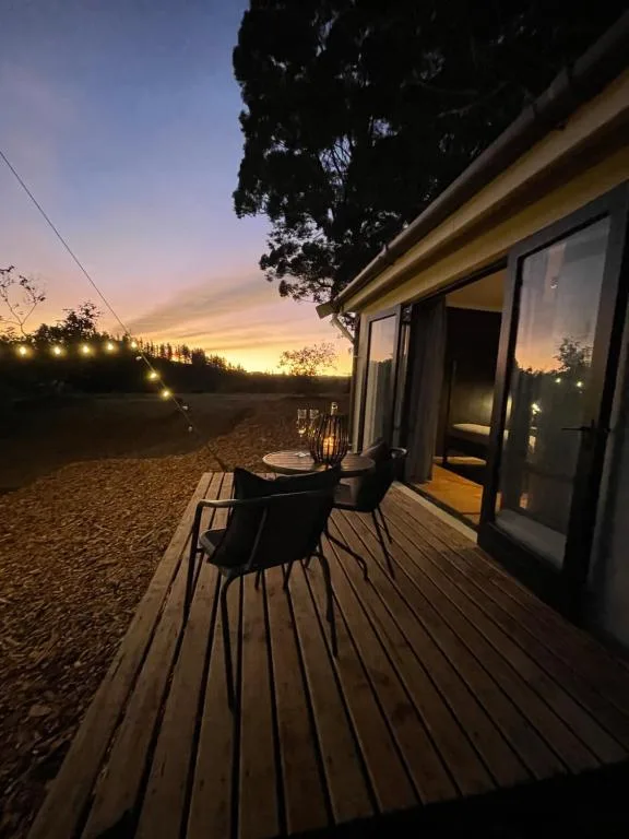 Wooden deck at sunset with dining table and outdoor seating area