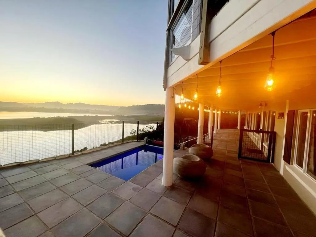 Sunset view from covered deck with pool and lagoon vista