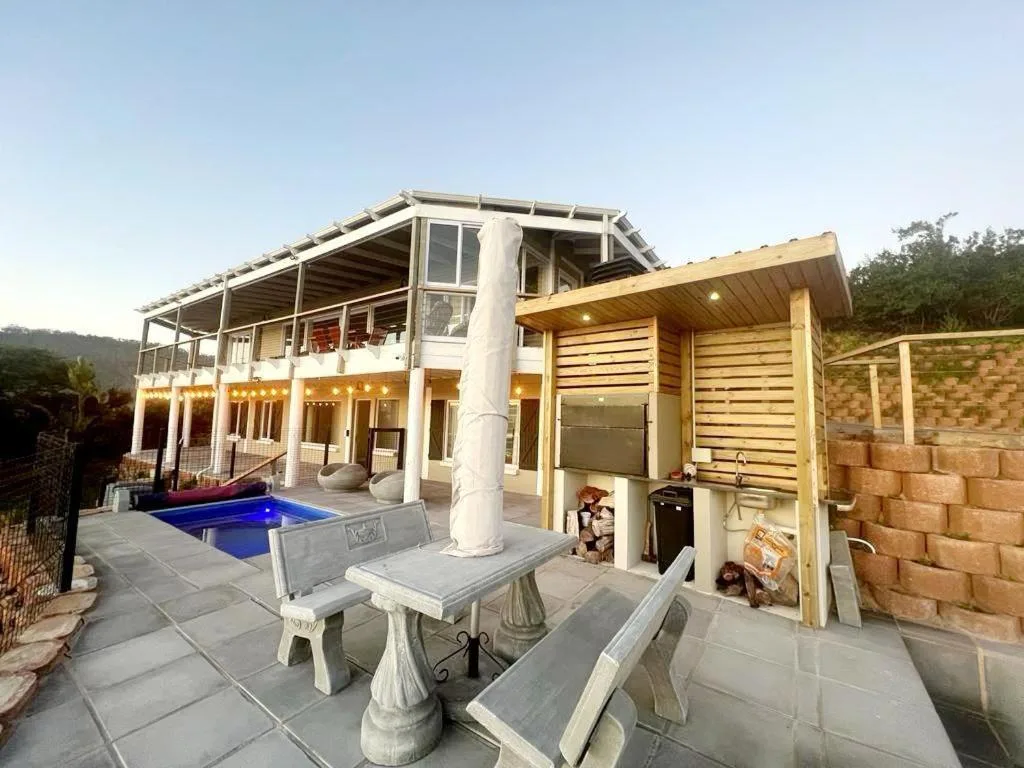 Outdoor patio with pool, seating tables, and mountain views