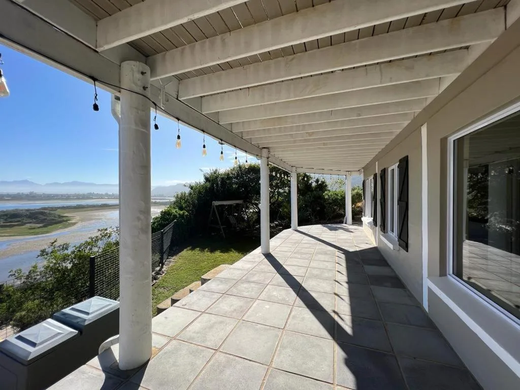 Covered patio with lagoon views, pendant lights, and mountain landscape beyond