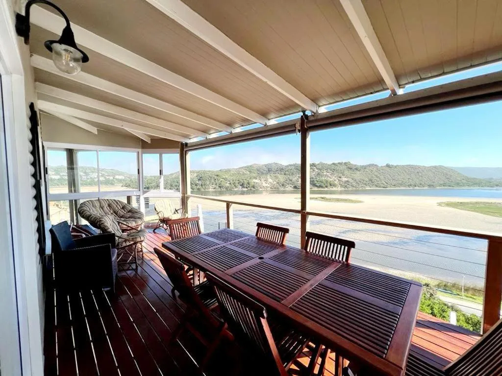 Covered deck with dining table overlooking Sedgefield Lagoon and mountains