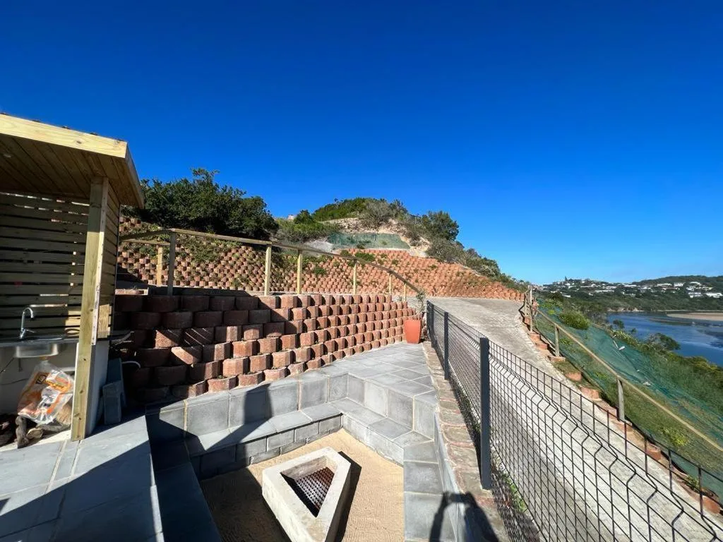 Outdoor deck with seating, fire pit, and lagoon views beyond