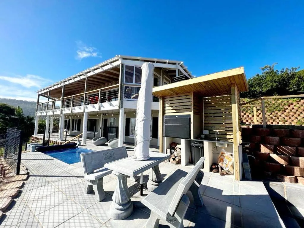Patio area with picnic tables and mountain views behind pool