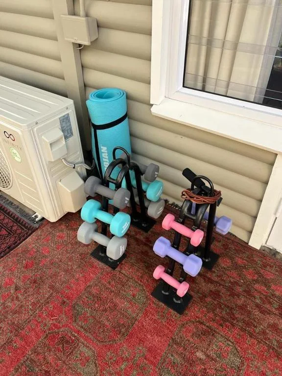 Home gym equipment including yoga mat, dumbbells, and exercise accessories