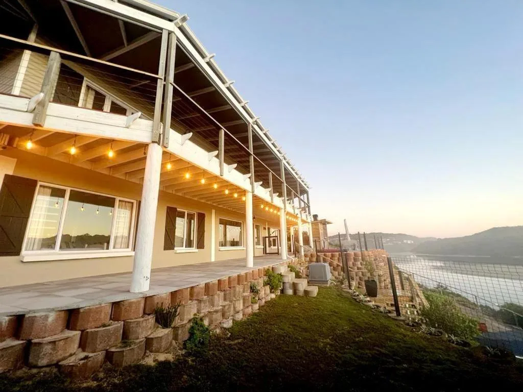 Modern beachfront home with covered deck and lagoon views at sunset