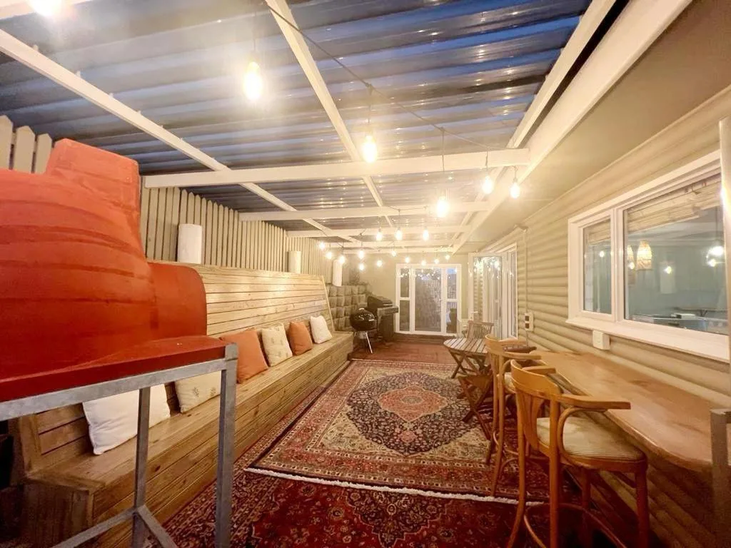 Bright lounge with red sofa, wooden furnishings, and patterned rug