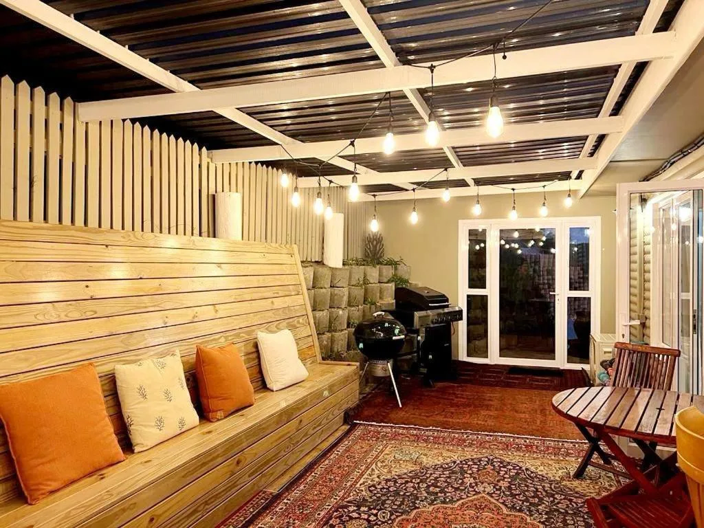 Modern lounge with wooden built-in seating, pendant lights, and glass doors