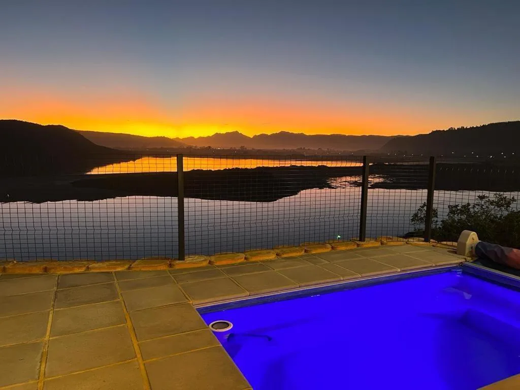 Swimming pool at sunset overlooking Sedgefield Lagoon and mountains