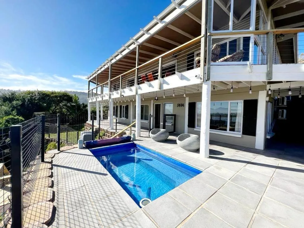 Modern backyard pool with deck, loungers, and mountain views