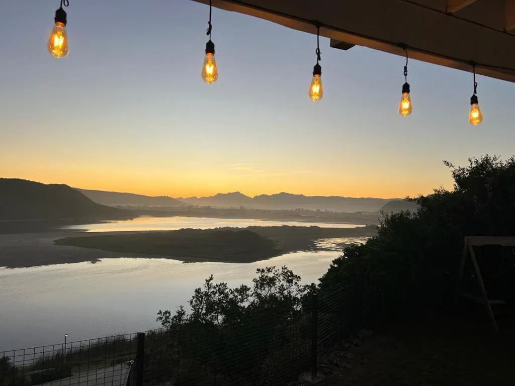 Sunset over Sedgefield Lagoon with mountains and golden pendant lights overhead