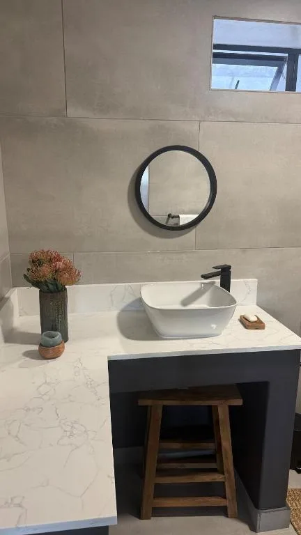 Modern bathroom vanity with round mirror and vessel sink basin