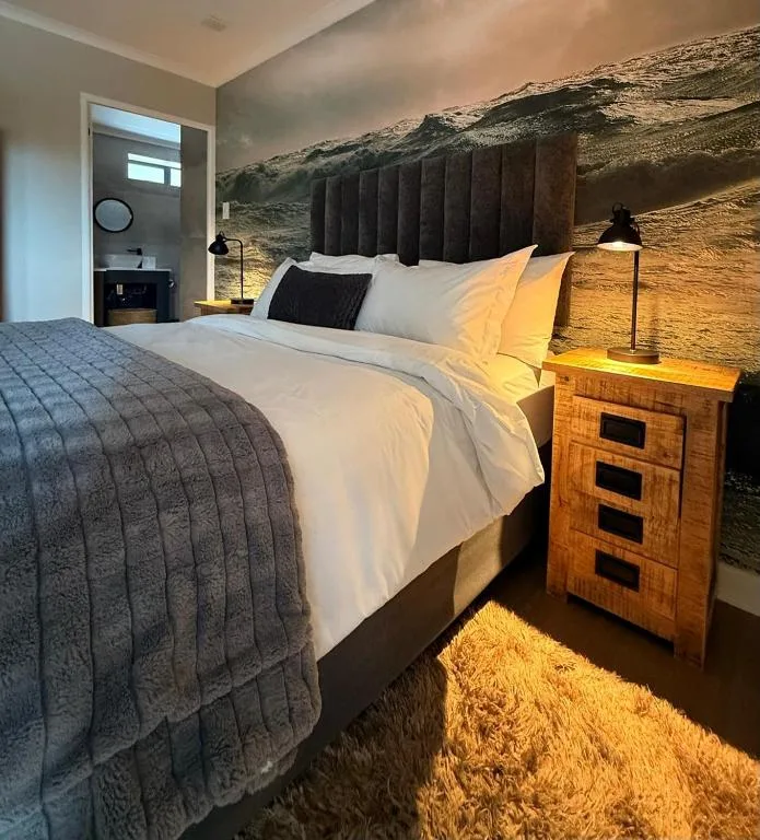 Modern bedroom with queen bed, wooden nightstand, and contemporary headboard