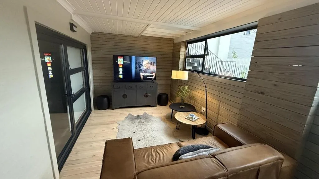 Modern living room with brown leather sofa and wall-mounted television