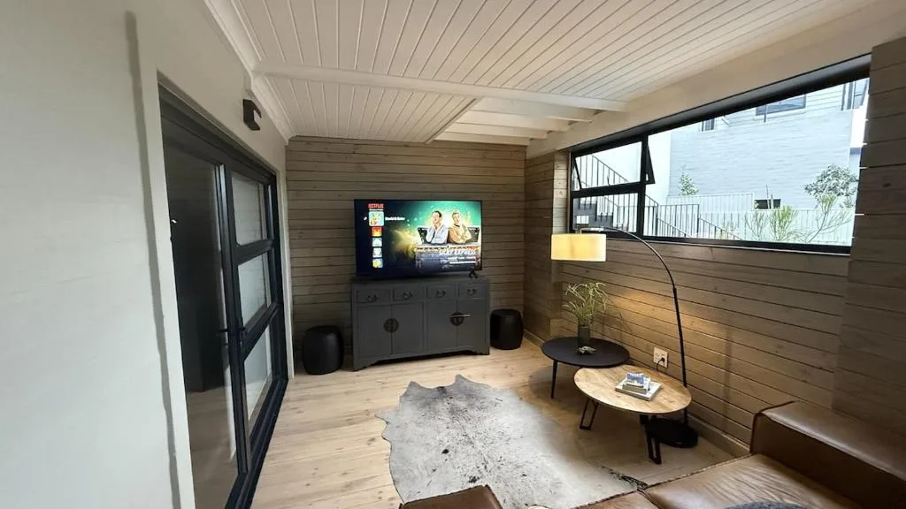 Modern lounge with TV, wooden walls, and contemporary furnishings