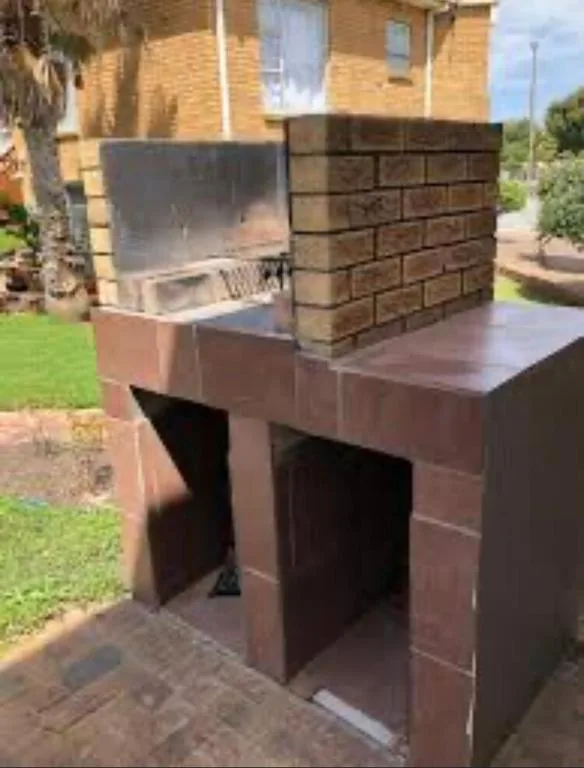 Outdoor brick braai and built-in grill on patio area