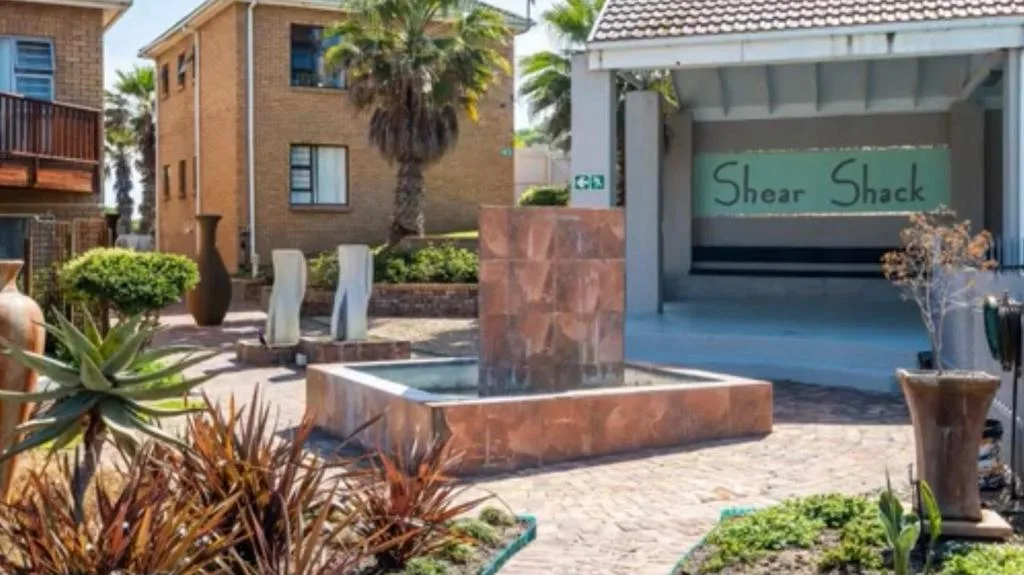 Brick building entrance with palm trees and landscaped courtyard garden area
