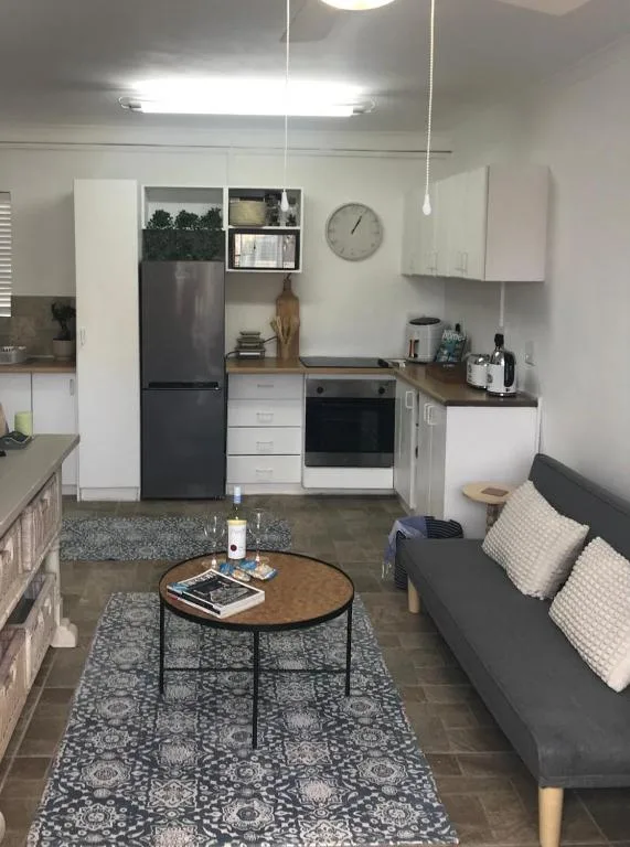 Modern kitchen with white cabinetry, stainless steel appliances, and open shelving