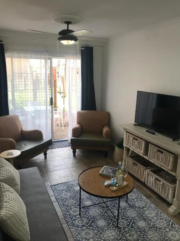 Bright lounge with comfortable seating, TV, and sliding doors to deck