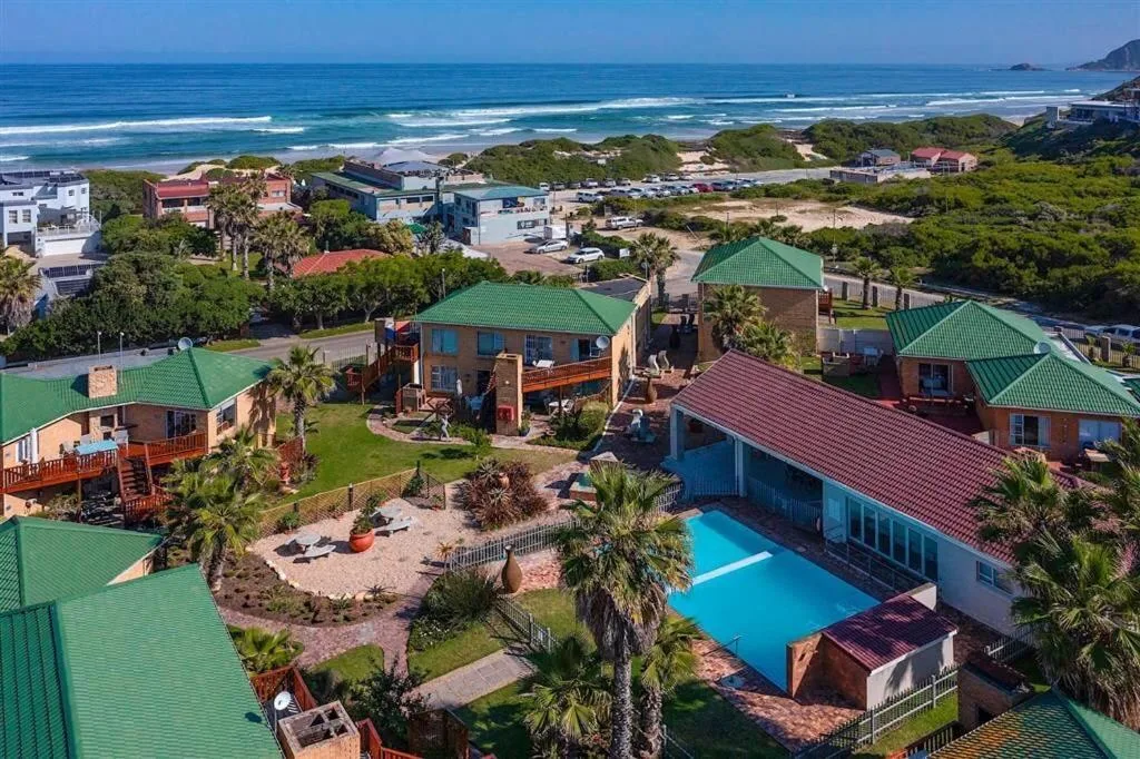 Aerial view of beachfront property complex with ocean and dunes
