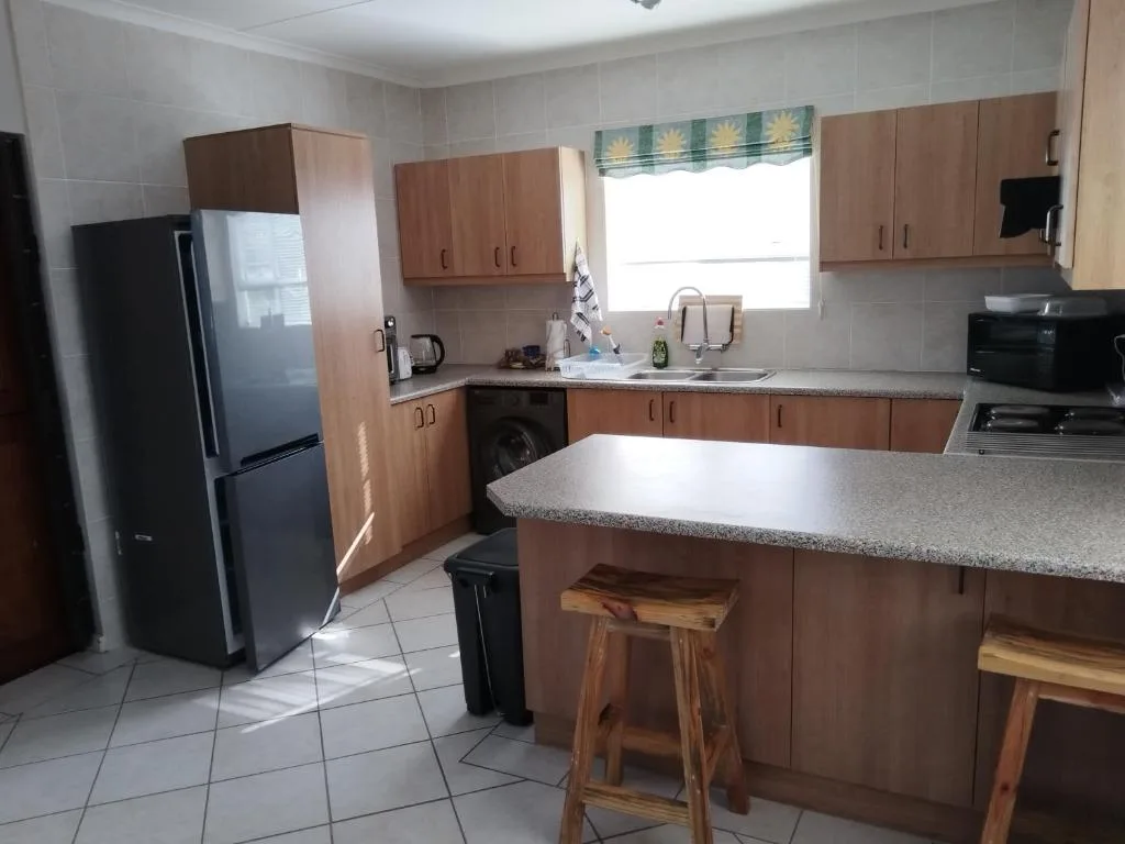 Spacious kitchen with wooden cabinetry, granite countertops, and stainless steel appliances