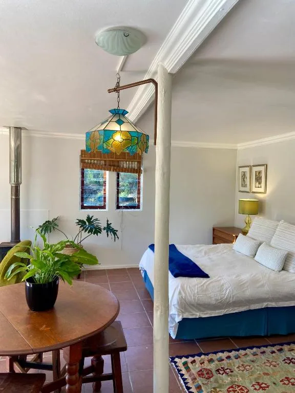 Bedroom with white bed, decorative stained glass pendant lamp overhead