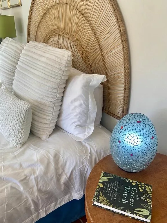 Decorative pillows and turquoise mosaic lamp on wooden bedroom table