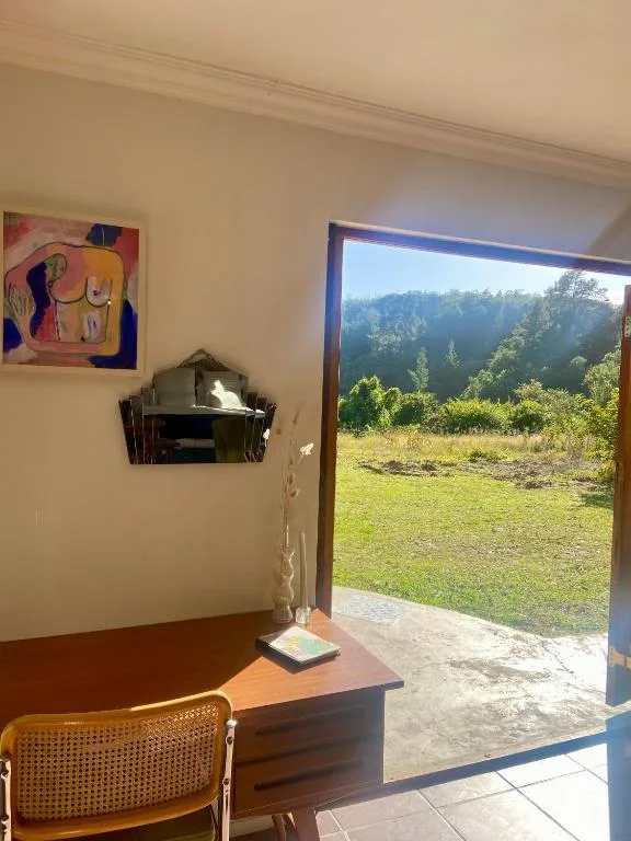 Forested landscape with green grass visible through large open doors