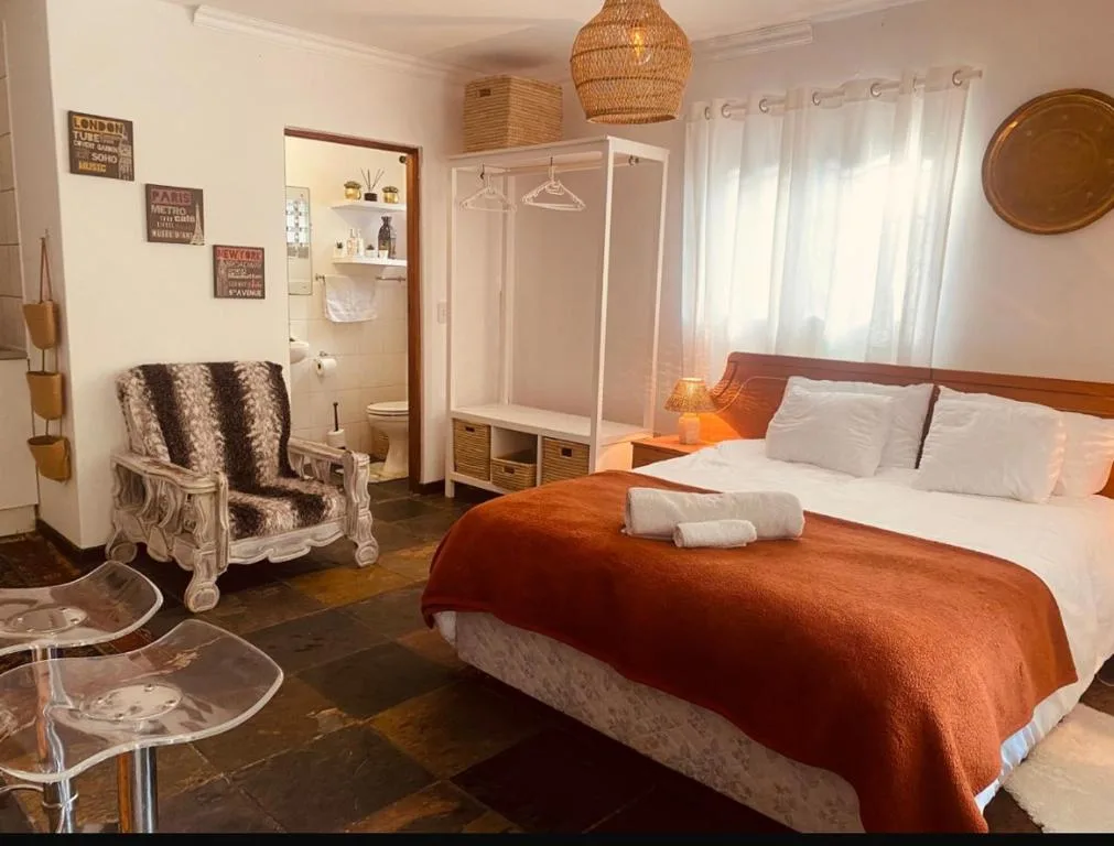 Bright bedroom with queen bed, ensuite bathroom, and comfortable seating area