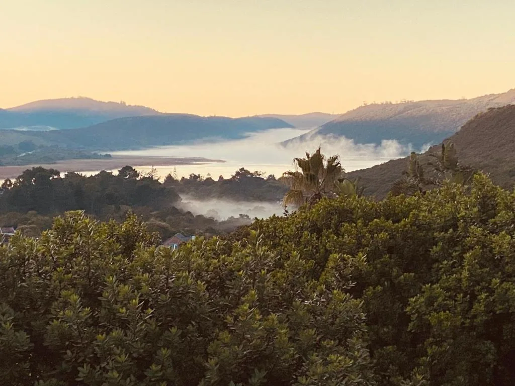 Misty lagoon and mountains at sunrise from property overlook