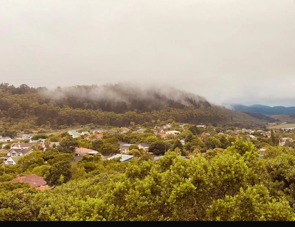 Misty mountain vista overlooking lush valley and scattered houses below