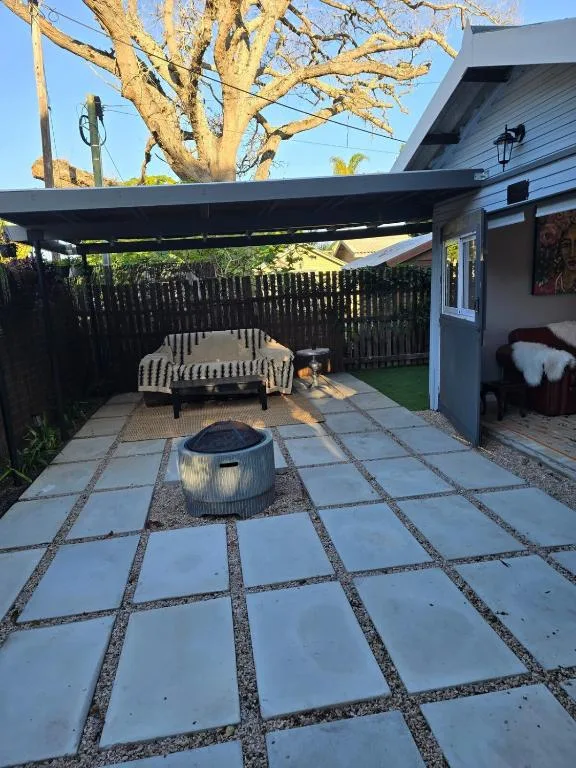 Shaded patio area with seating, fire pit, and retractable awning