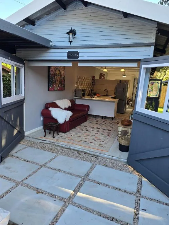 Modern garage conversion with open doors revealing lounge and kitchen interior