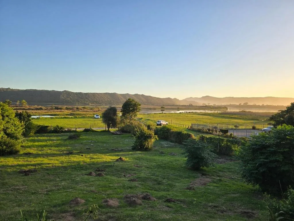 Scenic valley landscape with mountains, green fields, and distant farmland