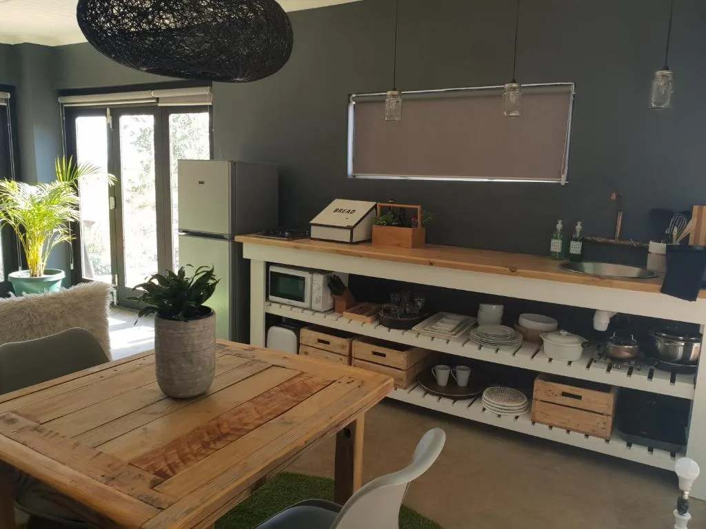Modern kitchenette with wooden countertop, storage shelves, and appliances