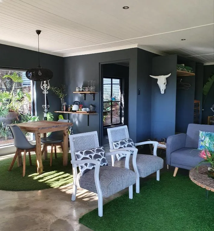 Open-plan lounge and dining area with blue accent walls and contemporary furnishings