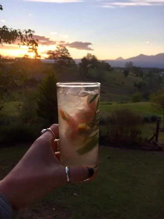 Sunset over mountains with refreshing drink overlooking scenic landscape