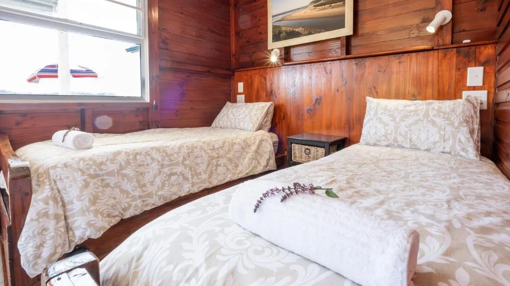 Twin bedroom with warm wooden walls and patterned bedding