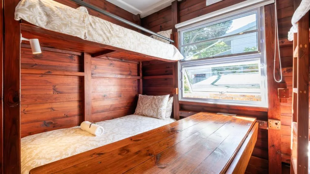 Wooden bedroom with bunk beds and natural light from windows