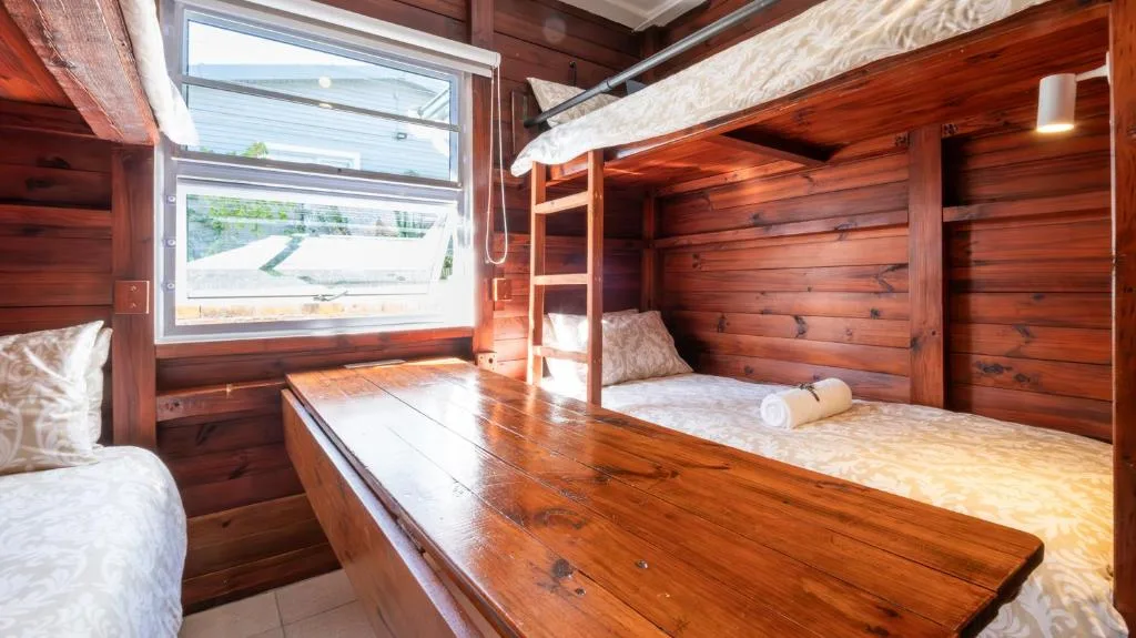 Wooden bunk bedroom with natural light and rolled towels