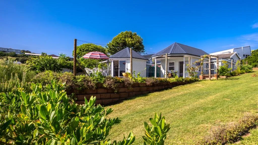 Modern white cottage with pitched roof and garden on manicured lawn