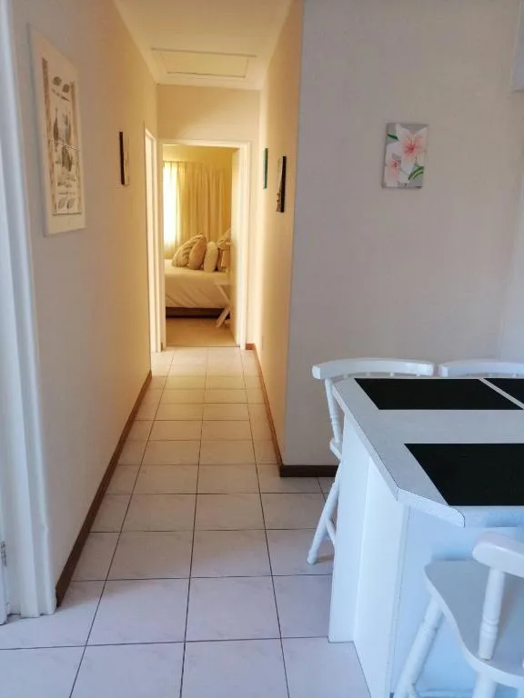Hallway with tiled floor leading to bedroom with golden curtains