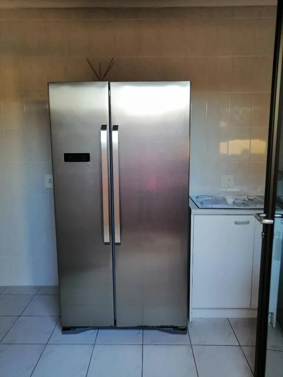 Stainless steel side-by-side refrigerator and dishwasher in modern kitchen