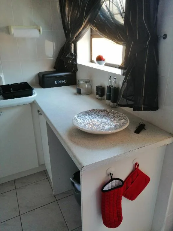 Kitchen counter with bread box, decorative bowl, and red kitchen towels