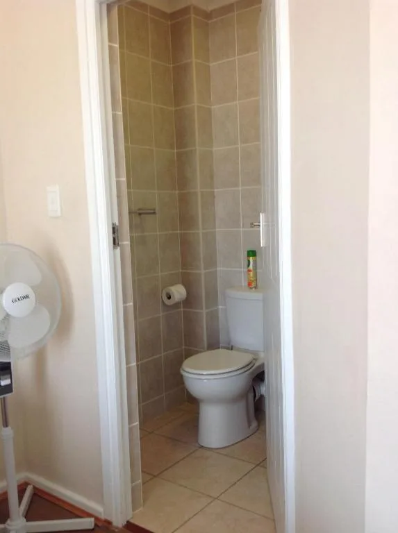 Compact bathroom with toilet, tiled walls, and basic amenities