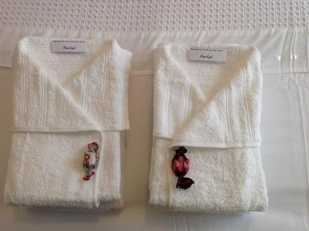 Welcome bathrobes with embroidered initials on white bedding