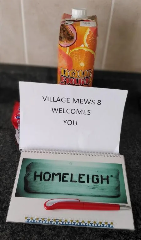 Welcome package with juice bottle and Homeleigh property sign for guests