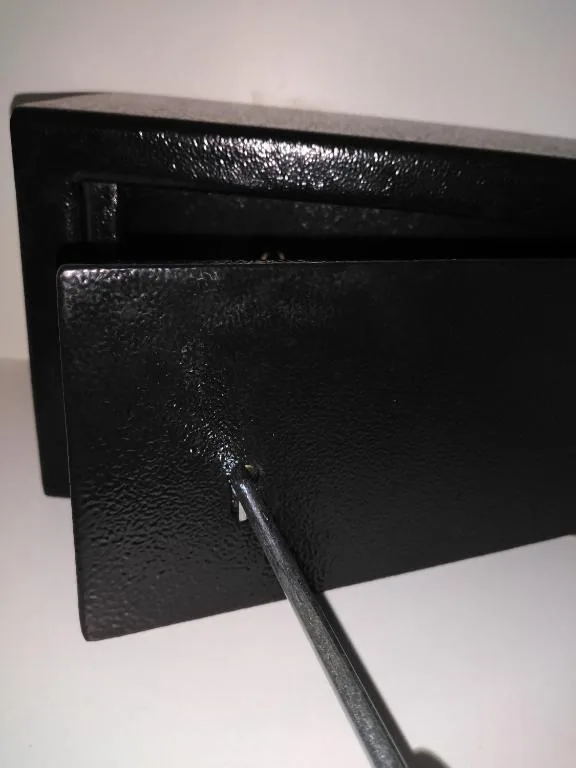 Close-up of black metal mailbox mounted on white wall