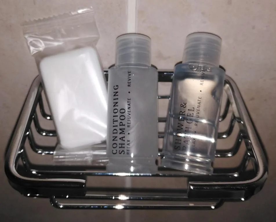 Bathroom amenities basket with conditioning shampoo and shower gel bottles