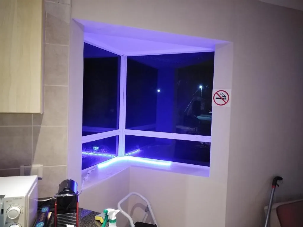 Modern window nook with blue ambient lighting and scenic night view